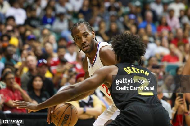 Kawhi Leonard of the Los Angeles Clippers is defended by Collin Sexton of the Utah Jazz during the first half of the preseason game at SimpliFi Arena...