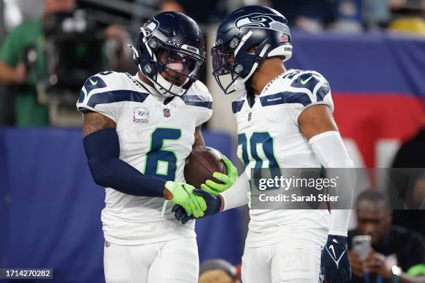 Quandre Diggs of the Seattle Seahawks shakes hands with Julian Love after intercepting the ball during the fourth quarter against the New York Giants...