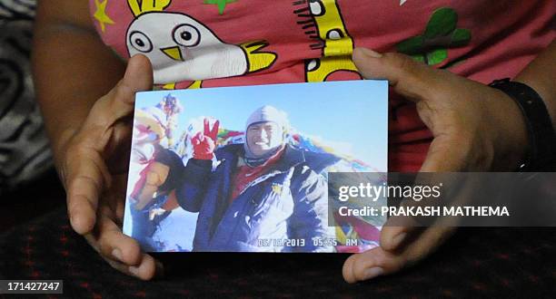 Doma Sherpa, the wife of Nepalese climber Sona Sherpa, holds a picture of her husband, who was killed by Taliban militants at Nanga Parbat base camp...