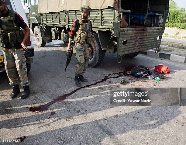 Indian army soldiers stand guard next to their vehicle which came under the attack of rebel militants on June 24, 2013 in Srinagar, the summer...