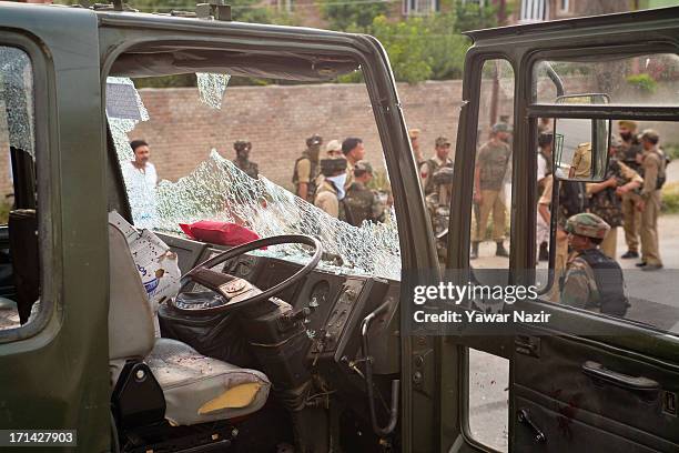 Indian army soldiers stand guard next to their vehicle which came under the attack of rebel militants on June 24, 2013 in Srinagar, the summer...