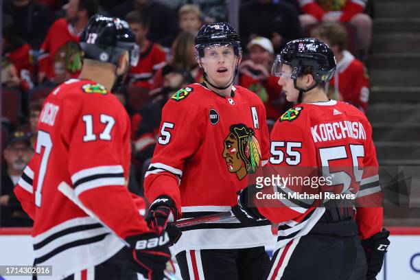 Nick Foligno, Connor Murphy and Kevin Korchinski of the Chicago Blackhawks talk against the St. Louis Blues during the first period of a preseason...