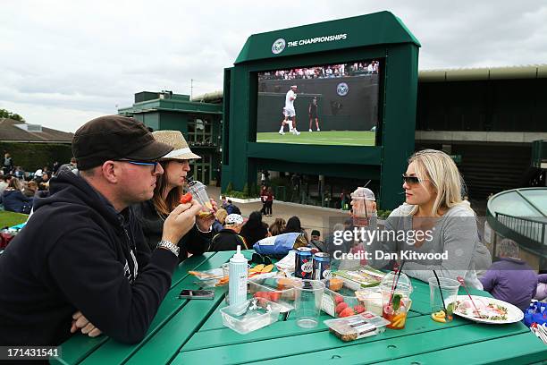 Spectators enjoy strawberries and Pimms on Murray Mount as they watch the action on the big screen during day one of the Wimbledon Lawn Tennis...