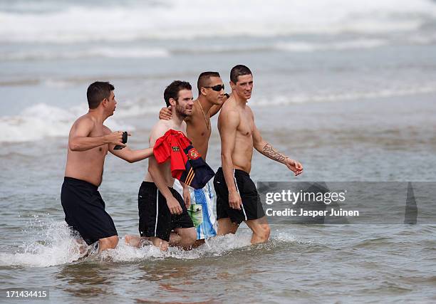 Fernando Torres and Juan Mata of Spain walk with fans out of the sea after a swim at the Playa Futuro on June 24, 2013 in Fortaleza, Brazil.