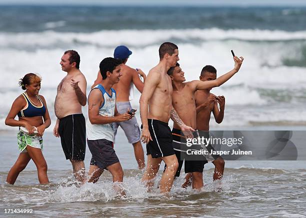 Fernando Torres of Spain walk out of the sea surrounded by young fans after a swim at the Playa Futuro on June 24, 2013 in Fortaleza, Brazil.