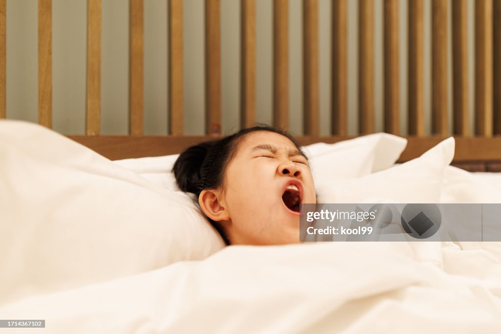 Little girl is resting at the hotel and yawning