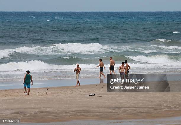 Jesus Navas and his teamate Victor Valdes of Spain walk into the sea for a swim at the Playa Futuro on June 24, 2013 in Fortaleza, Brazil.