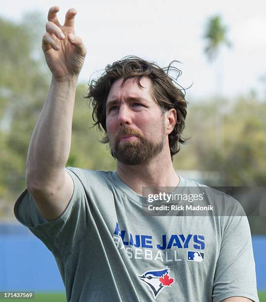 Dickey, the newly acquired knuckle ball ace for the Toronto Blue Jays, shows his release to pitching coach Pete Walker prior to a light catch session...