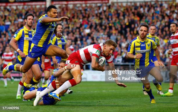 Sam Tomkins of Wigan dives over to score a try in the tackle of Warrington's Brett Hodgson during the Super League match between Warrington Wolves...