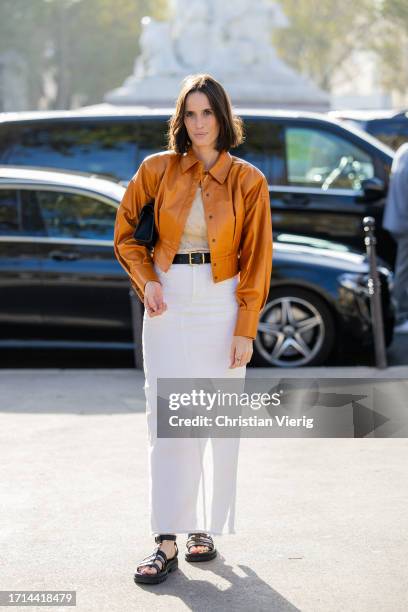 Astrid Boutrot wears brown jacket, white skirt outside Stella McCartney during the Womenswear Spring/Summer 2024 as part of Paris Fashion Week on...