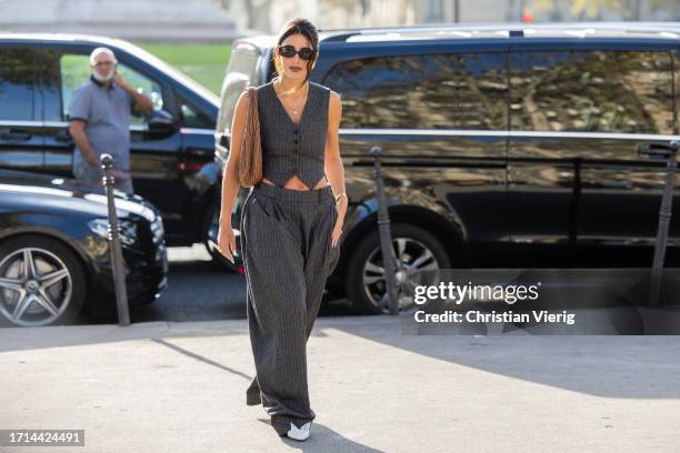 Bettina Looney wears grey vest, wide leg pants, brown bag outside Stella McCartney during the Womenswear Spring/Summer 2024 as part of Paris Fashion...