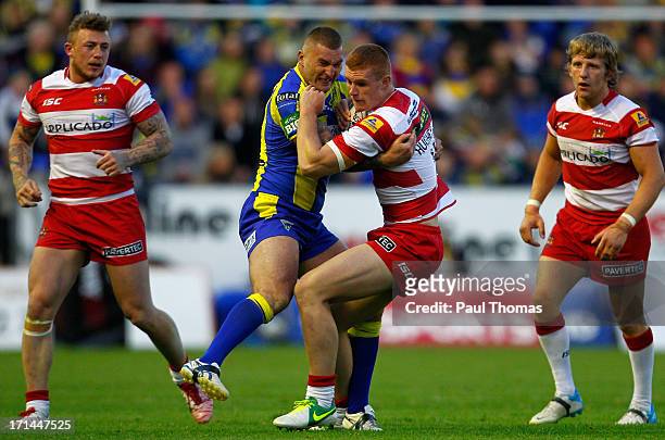 Jack Hughes of Wigan is tackled by Paul Wood of Warrington during the Super League match between Warrington Wolves and Wigan Warriors at the...