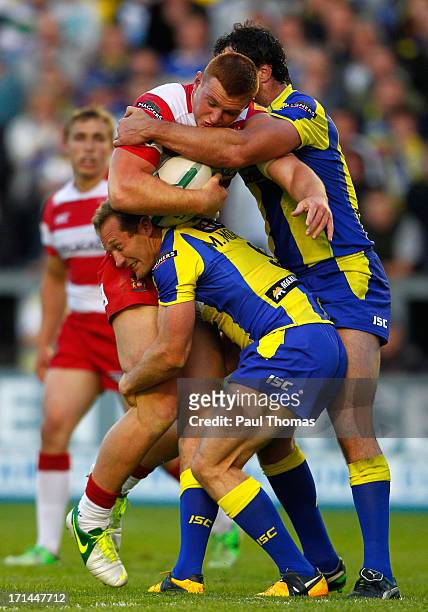 Jack Hughes of Wigan is tackled by Adrian Morley and Michael Monaghan of Warrington during the Super League match between Warrington Wolves and Wigan...