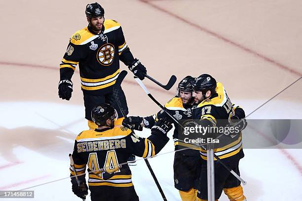 Milan Lucic of the Boston Bruins celebrates with his teammates Nathan Horton, David Krejci, and Dennis Seidenberg after scoring a goal in the third...
