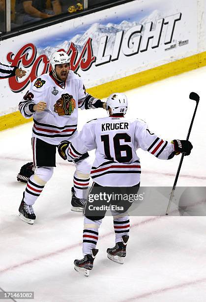 Dave Bolland of the Chicago Blackhawks celebrates with Marcus Kruger after scoring the game winning goal late in the third period against Tuukka Rask...