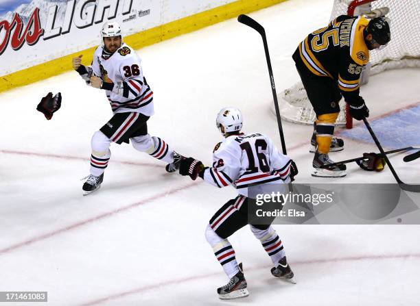 Dave Bolland of the Chicago Blackhawks celebrates with Marcus Kruger after scoring the game winning goal late in the third period against Tuukka Rask...