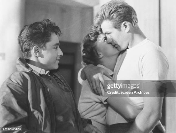 Sal Mineo looks on as James Dean and Natalie Wood embrace in a scene from the 1955 film 'Rebel Without a Cause'.
