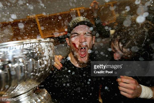 Andrew Shaw of the Chicago Blackhawks celebrates with the Stanley Cup in the locker room after defeating the Boston Bruins in Game Six of the 2013...