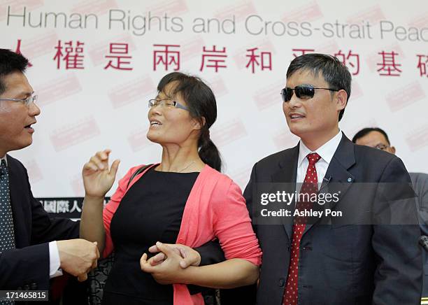 Chinese lawyer and human rights activist Chen Guangcheng and his wife Yuan Weijing talk to the legislator Lin Jialong at the Legislative Yuan on June...