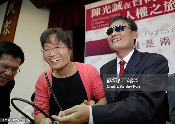 Chinese lawyer and human rights activist Chen Guangcheng and his wife Yuan Weijing shake hands with a supporter at the Legislative Yuan on June 25,...