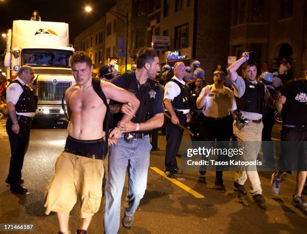 Police officer arrests a man as Chicago Blackhawks fans celebrate the win over the Boston Bruins in Game Six of the 2013 NHL Stanley Cup Final on...