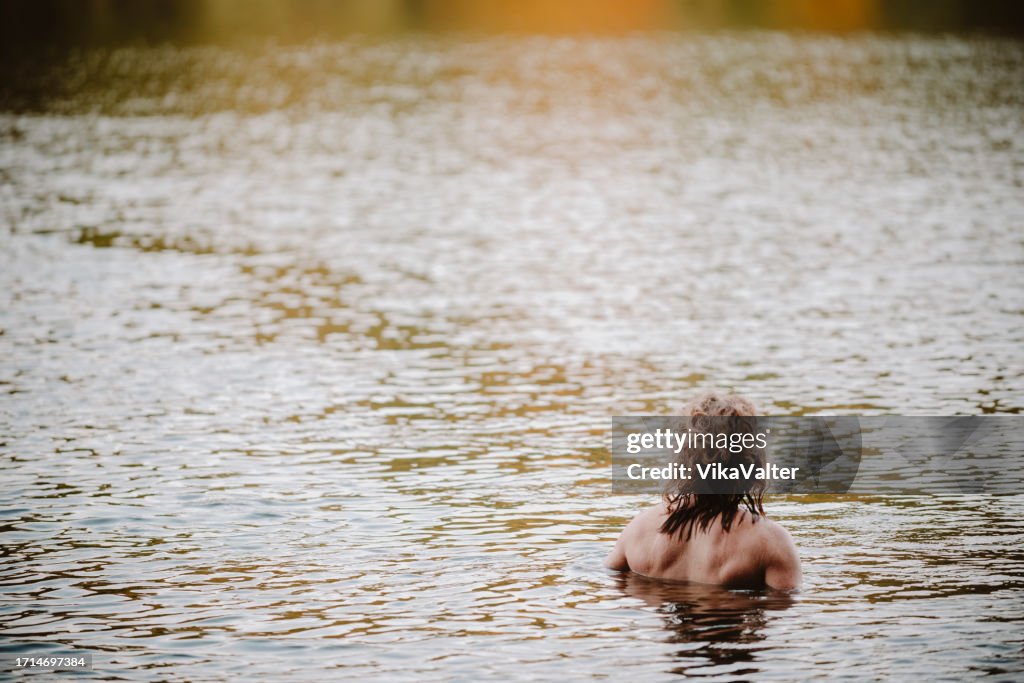 Man in his mid 40's swimming in autumn lake