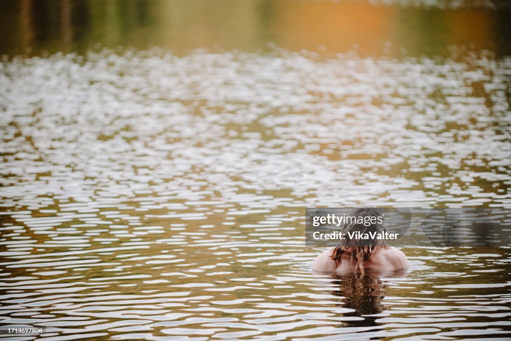 Man in his mid 40's swimming in autumn lake