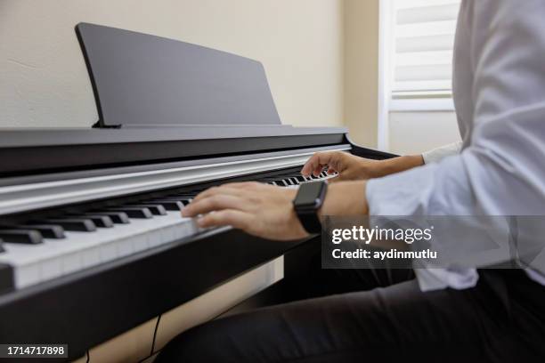 soulful melody: hands of a man creating music on a piano - classical orchestral music stock pictures, royalty-free photos & images