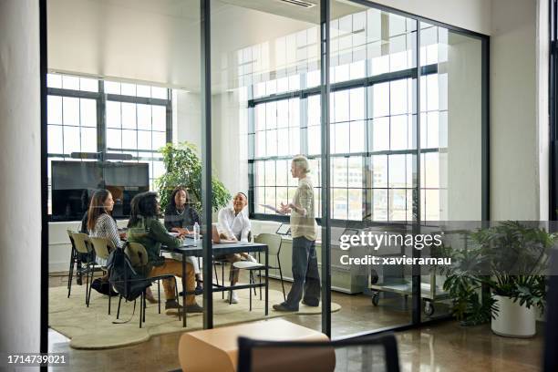 colegas sonrientes que se reúnen en una moderna sala de conferencias - gestor de proyectos fotografías e imágenes de stock