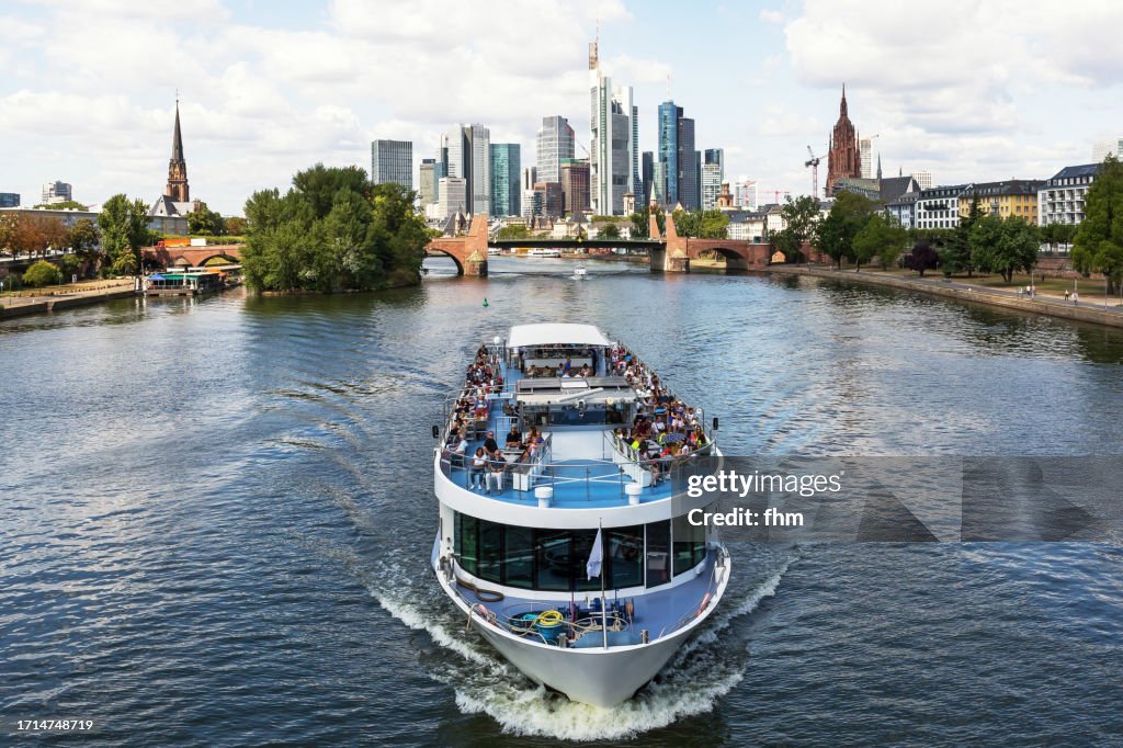 Tourboat with many tourists on Main River with Frankfurt/ Main Skyline (Hesse, Germany)