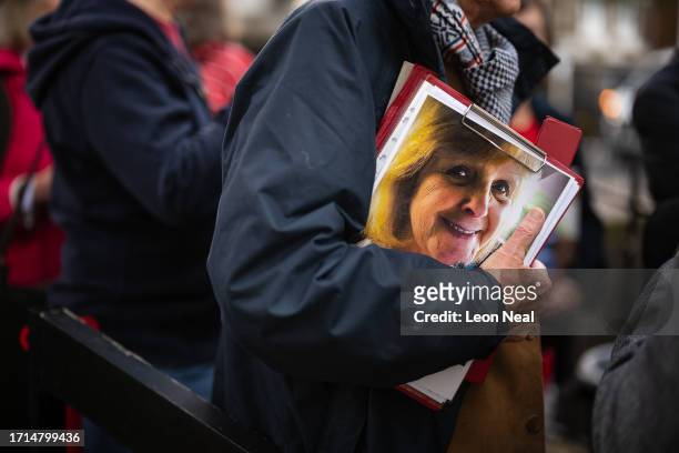 Person holds a framed photograph of a loved one as relatives gather ahead of the first day of the second phase of the UK Covid-19 public inquiry at...