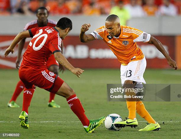 Ricardo Clark of Houston Dynamo attempts to get around Matias Laba ofToronto FC at BBVA Compass Stadium on June 22, 2013 in Houston, Texas.