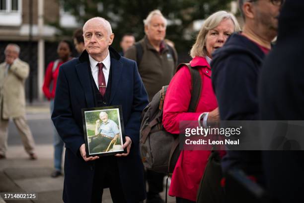 Larry Byrne holds a framed photograph of his father, also named Larry Byrne, who died during the pandemic, ahead of the first day of the second phase...