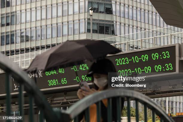 An electronic ticker displays stock figures in Pudong's Lujiazui Financial District in Shanghai, China, on Monday, Oct. 9, 2023. Chinese stocks edged...