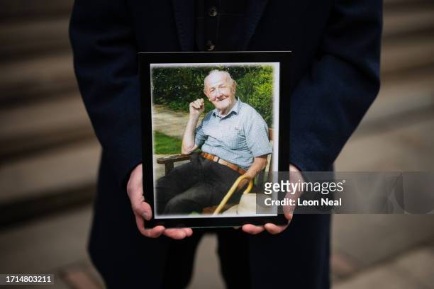 Larry Byrne holds a framed photograph of his father, also named Larry Byrne, who died during the pandemic, ahead of the first day of the second phase...