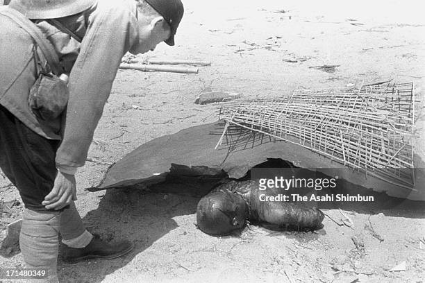 Japanese Imperial Army investigation team member checks a body of the Hiroshima atomic bomb victim, taken photographed between August 10 to 12, 1945...