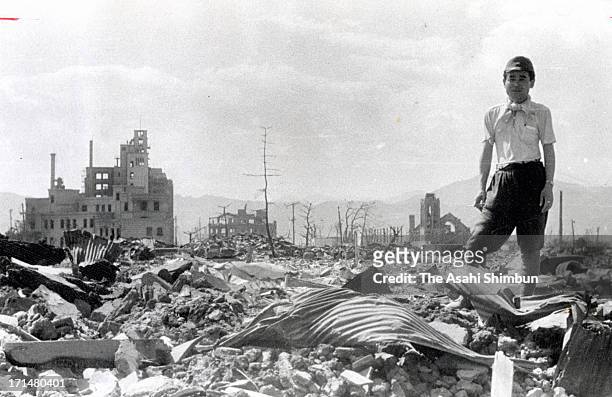 Man stand on the debris after the atomic bomb completely destroyed the city in August 1945 in Hiroshima, Japan. The world's first atomic bomb was...