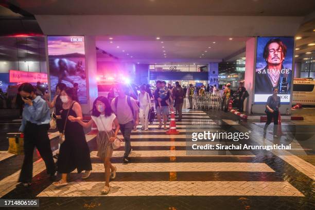 People exit the Siam Paragon mall as a shooting incident was still ongoing inside on October 03, 2023 in Bangkok, Thailand. A man opened fire inside...