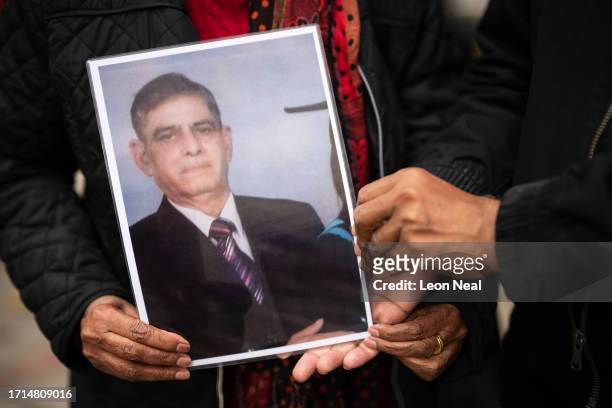Kaithreen Surinder and Robin Sansarpuri hold a photograph of their relative Surinder Kumar, who died during the pandemic, ahead of the first day of...