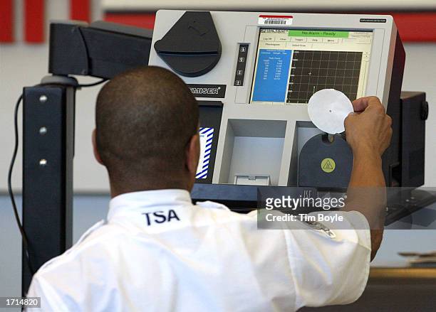 An airport security screener inputs luggage sampling into an Explosives Trace Detection device January 8, 2003 in Terminal 3 at Chicago's O'Hare...