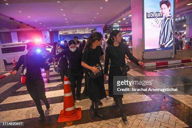 People exit the Siam Paragon mall as a shooting incident was still ongoing inside on October 03, 2023 in Bangkok, Thailand. A man opened fire inside...