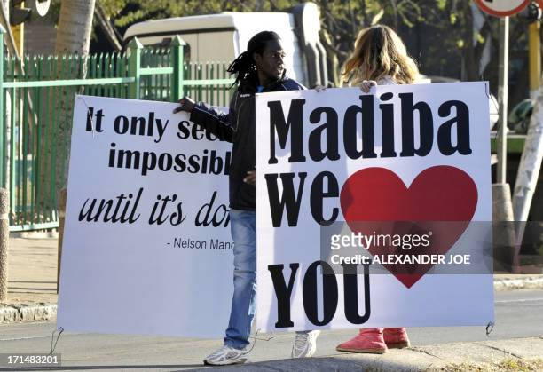 South Africans put up signs wishing well former South African president Nelson Mandela on June 25, 2013 outside of the Mediclinic heart hospital in...
