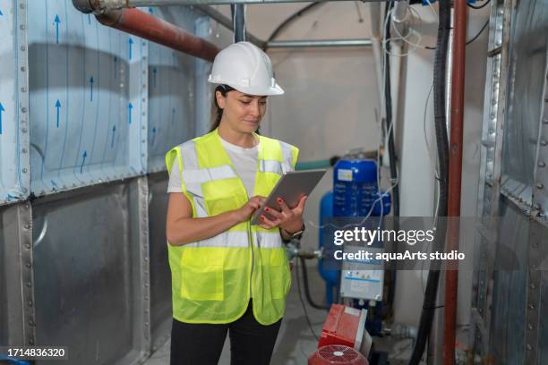 female engineer checking the water storage system - basement stock pictures, royalty-free photos & images