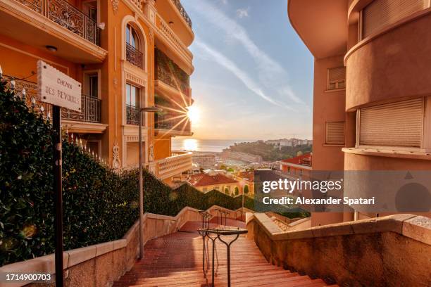 sunrise seen through the steep streets of monaco - monaco stock-fotos und bilder