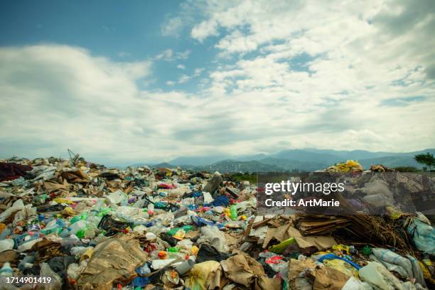 garbage dump under dramatic sky. environmental damage, air and water pollution and ecology crisis concept. - landfill stock pictures, royalty-free photos & images