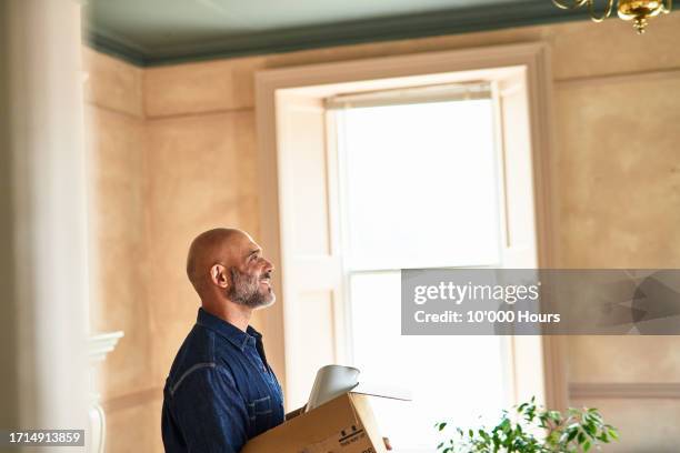 home owner carrying box into new house - good move concept stock pictures, royalty-free photos & images