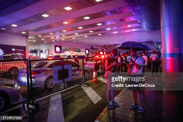 People gather outside the Siam Paragon mall after being evacuated after a shooting incident inside on October 03, 2023 in Bangkok, Thailand. A man...