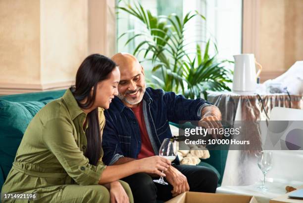 happy couple celebrating moving into new home - good move concept stock pictures, royalty-free photos & images
