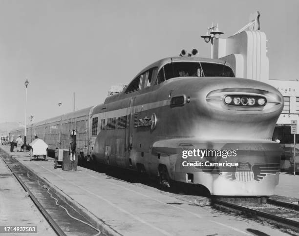 Electric passenger train sitting in the station as passengers board. The train is from the city of Las Vegas Union Pacific Railroad.
