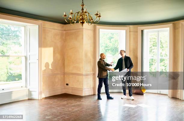 home owner shaking hands with building developer at new house - good move concept stock pictures, royalty-free photos & images